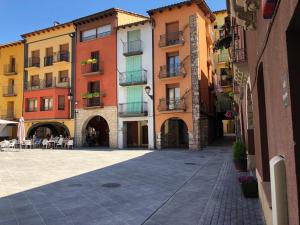 a group of buildings with tables and chairs in a courtyard at Apartamento vacacional in El Pont de Suert