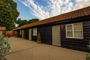 una casa negra con garaje y entrada en The Cherry Tree Rochford en Rochford