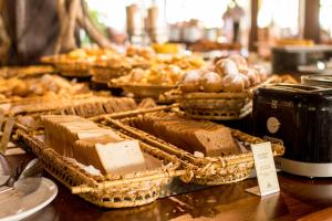 a wooden table topped with lots of pastries at NANNAI Muro Alto in Porto De Galinhas