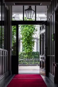 una puerta abierta a una habitación con alfombra roja en The Adria en Londres