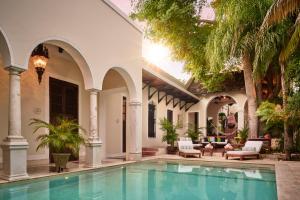a patio with a pool, chairs, and a pool table at Casa Lecanda Boutique Hotel in Mérida