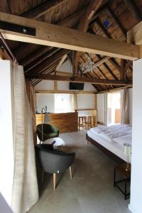 a bedroom with a bed and a chair at Ferienhaus am Rheinsteig / Nähe Hindenburghöhe / Loreley in Lykershausen