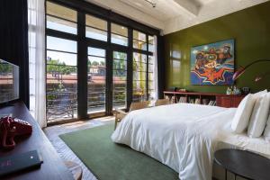 a bedroom with a large bed and a large window at Stamba Hotel in Tbilisi City