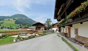 przejście z ławkami i budynek z górami w tle w obiekcie Hof Obertann w mieście Kirchberg in Tirol