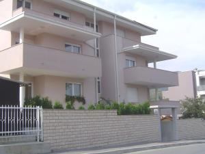 a white building with a white fence in front of it at Apartmani Almica in Zagreb