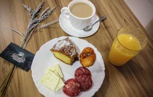 a table with a plate of food and a cup of coffee at Pousada Bem Estar in Cambará