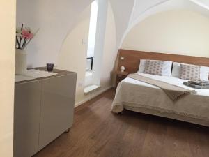 um quarto com uma cama e uma cómoda com flores em VIA DANTE LUXURY em Matino