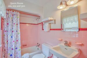Baño rosa con lavabo y aseo en King Charles Hotel, en Ocean City