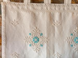 a white curtain with blue embroidery on it at Angolo di paradiso sul mare in Geremèas