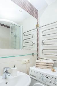 een witte badkamer met een wastafel en een spiegel bij Apartment Amber Sky in Palanga