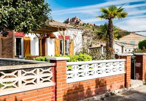 een bakstenen hek voor een huis met een palmboom bij Ca la Magdalena in Cardona