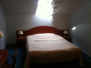 - une chambre avec un lit et 2 tables de nuit avec des lampes dans l'établissement Guest House Guba, à Moletai