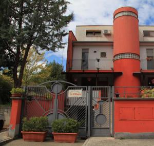 una casa roja con una puerta y algunas plantas en B&B La Villetta, en Benevento