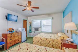 a bedroom with two beds and a ceiling fan at King Charles Hotel in Ocean City