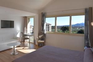 a bedroom with a bed and a large window at Castellu Rossu in Lucciana