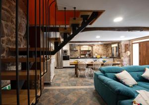 a living room with a blue couch and a kitchen at Casa de Anamá in Entrecinsa