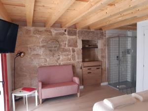 uma sala de estar com um sofá e uma parede de pedra em Casa Choupas em Cangas