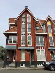 a red brick house with a car parked in front of it at North Sea Cottage Middelkerke in Middelkerke