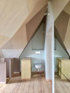 a bathroom with a toilet under the stairs at North Sea Cottage Middelkerke in Middelkerke