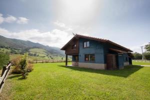 a small blue house in a field of grass at Primorías Boquerizo in Boquerizo