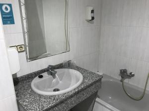 a bathroom with a sink and a bath tub at Alda Puerta Coruña in A Coruña