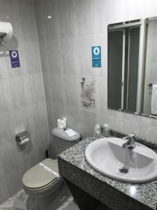 a bathroom with a sink and a toilet and a mirror at Alda Puerta Coruña in A Coruña