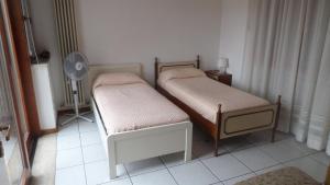 2 łóżka pojedyncze w pokoju z wentylatorem w obiekcie Residenza Capri w mieście Vicenza