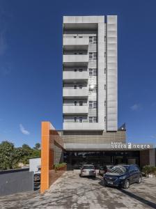 un edificio con coches estacionados frente a él en Hotel Serra Negra, en Betim