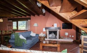 sala de estar con sofá azul y chimenea en Primorías Boquerizo, en Boquerizo