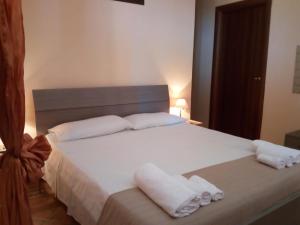 a bedroom with a large white bed with towels on it at B&B Dimora Marchese in Marina di Camerota