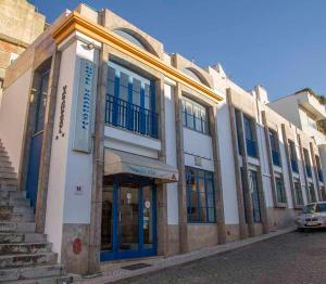 un bâtiment avec une voiture garée devant lui dans l'établissement Hotel Varandazul, à Palmela