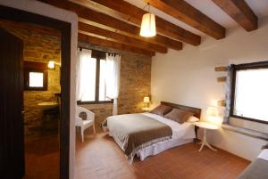 ein Schlafzimmer mit einem Bett und einem Waschbecken in einem Zimmer in der Unterkunft O Chardinet d'a Formiga in Aínsa