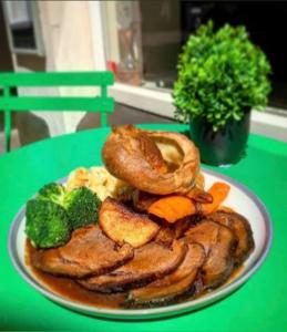 une assiette de nourriture avec du poulet et des légumes sur une table dans l'établissement The Coach and Horses Inn, à Chepstow