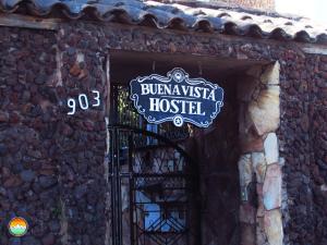 un cartel en un edificio con una puerta de hierro forjado en Buena Vista Hostel, en Ouro Preto