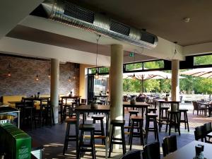 a restaurant with tables and chairs and windows at Hotel am Kurpark in Zinnowitz