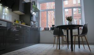 a kitchen with black cabinets and a table and chairs at KINDheitstRAUM in Erfurt