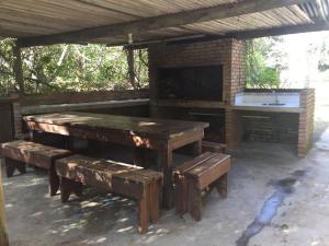 une grande table en bois et des bancs sous un pavillon dans l'établissement Casa Azul, à Maldonado