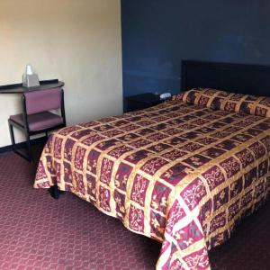 a hotel room with a bed and a desk at Country Host Inn in Texarkana