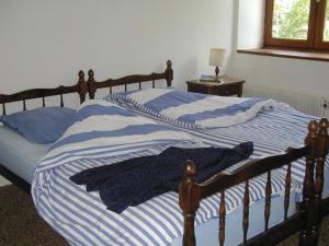 2 Betten mit blau und weiß gestreifter Bettwäsche in einem Schlafzimmer in der Unterkunft La Fontaine des Thiolles in Saint-Germain-lʼHerm