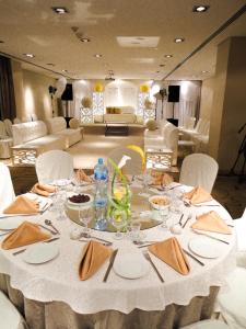 a table with a white table cloth and chairs and a room at The K Hotel in Manama