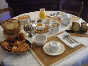 a table with a breakfast of bread and orange juice at La Metairie du Pont in Sainte-Hermine