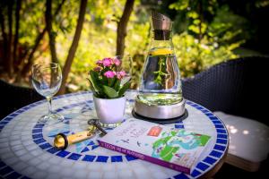 einen Tisch mit einer Flasche Öl, ein Buch und Blumen in der Unterkunft Boutique-Hotel Jungenwald in Traben-Trarbach