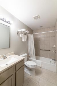 a bathroom with a toilet and a sink and a shower at Budget Inn & Suites Baton Rouge in Baton Rouge
