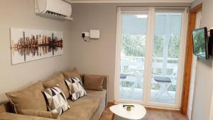 a living room with a couch and a window at Central Platinum Apartman Harkány in Harkány