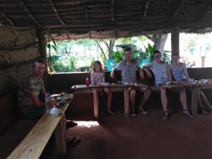 a group of people sitting at tables in a hut at Udesh Guest in Polonnaruwa