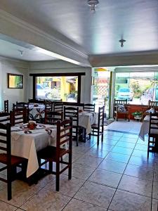 Pousada da Baleia في ريو داس أوستراس: مطعم فيه طاولات وكراسي في الغرفة