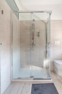 La salle de bains est pourvue d'une cabine de douche en verre et de toilettes. dans l'établissement Benvenuti in puglia B&B, à Crispiano