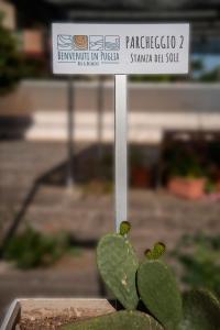 un signe devant un cactus vert dans l'établissement Benvenuti in puglia B&B, à Crispiano