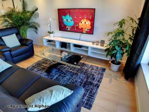 a living room with a couch and a flat screen tv at Apartment Alpha - 2 Bedrooms, Private Rooftop Patio with Hot Tub, BBQ and View in Ferragudo