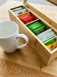 a cup of coffee and books in a wooden drawer at Cozy apartment with lake view in Trakai